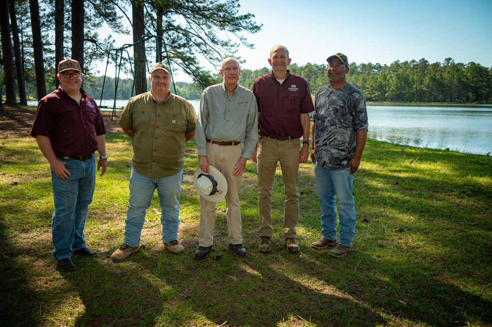 Five people standing in front of a lake.