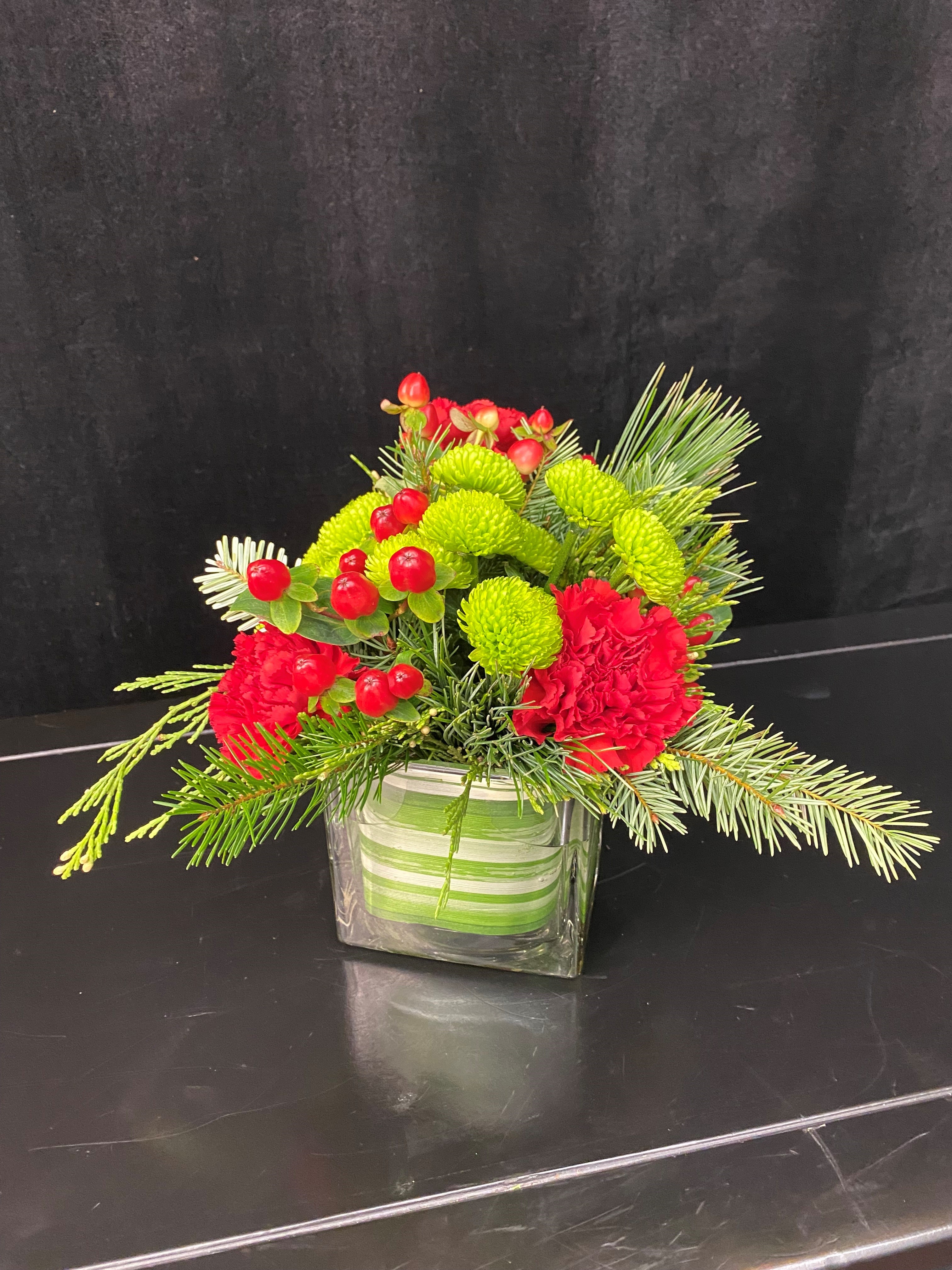 A small floral arrangement in a glass cube.