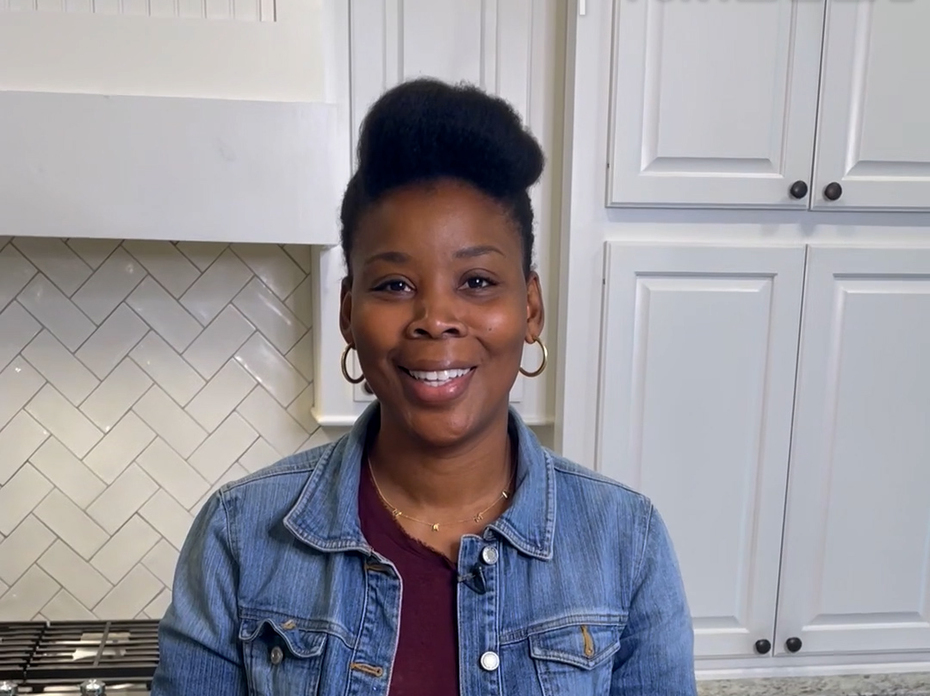 A woman stands in a kitchen.