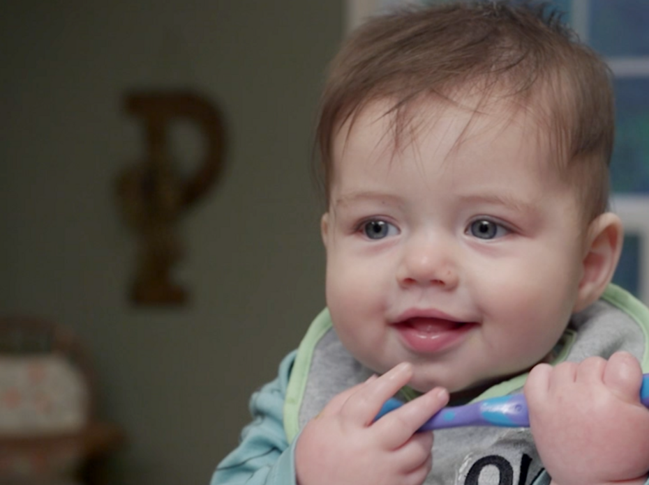 A 10-month-old baby eats homemade baby food.