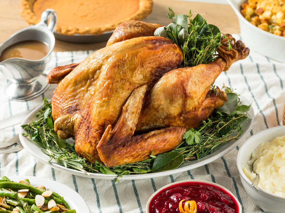 A roasted turkey surrounded by traditional side dishes.