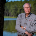 A man standing in front of a lake.