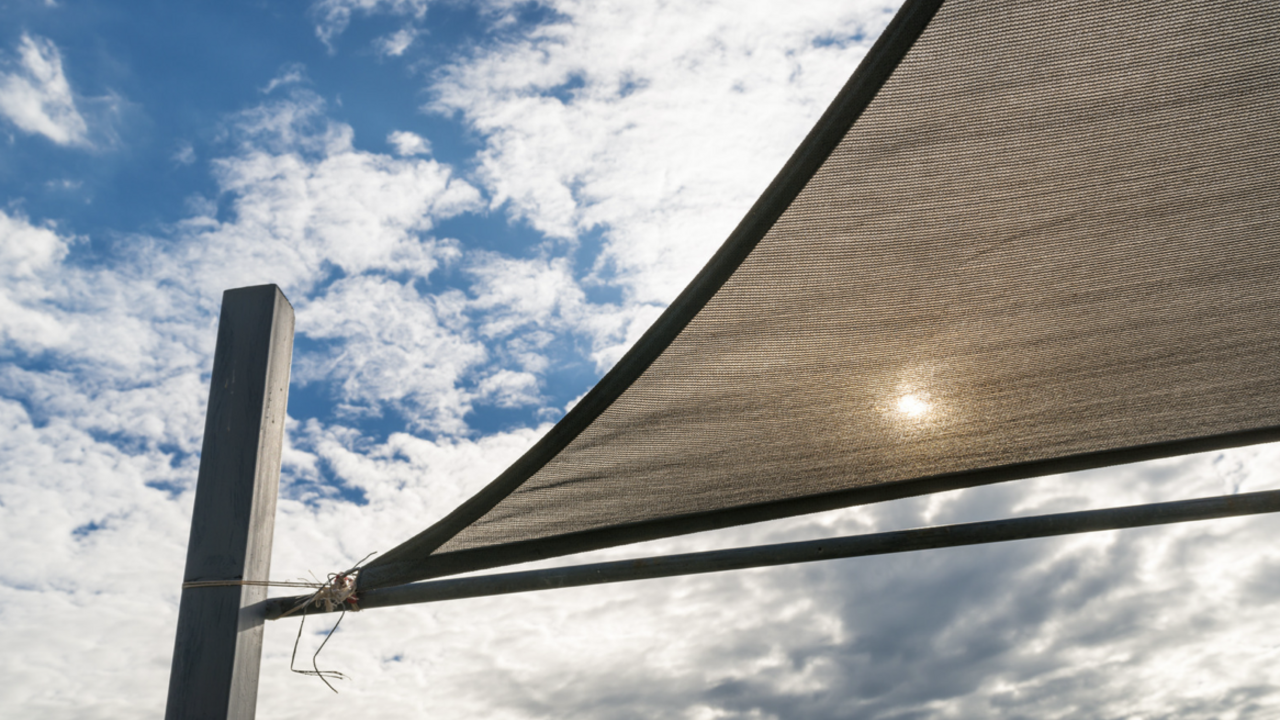A shade sail with cloudy blue sky.
