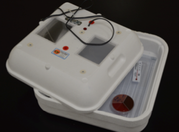 An egg incubator with the lid not fully covering it. 