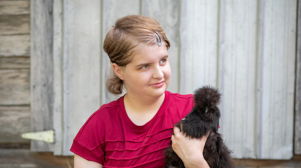 A child holding a chicken.