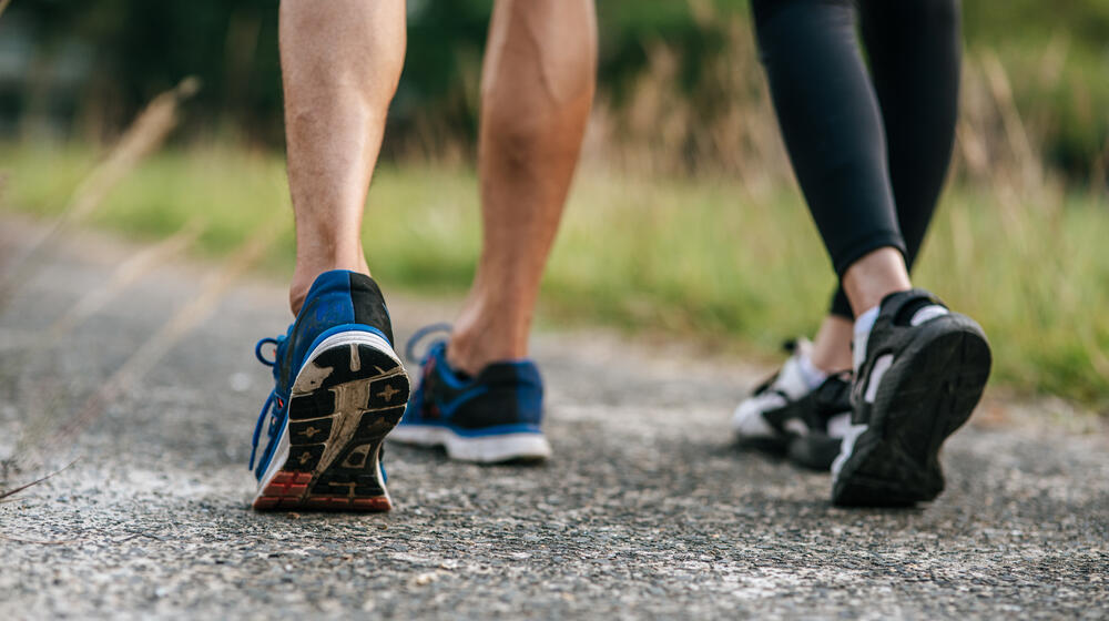 two people walking on a gravel trail