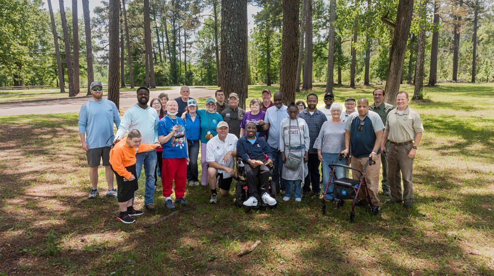 A group of people standing in front of trees.